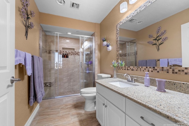 bathroom with vanity, an enclosed shower, and toilet