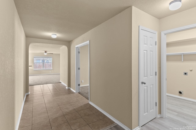 hallway with light tile patterned flooring and a textured ceiling