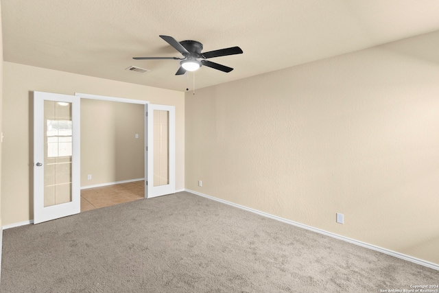 unfurnished bedroom featuring ceiling fan, light carpet, and french doors