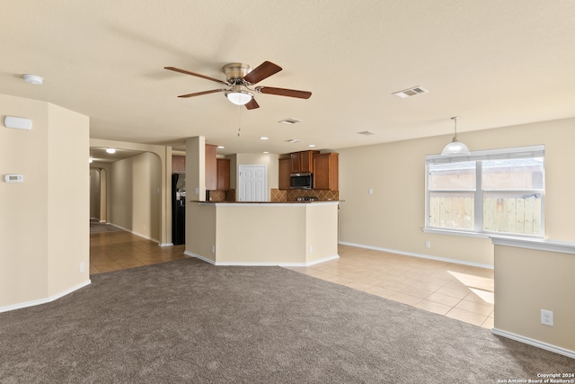 unfurnished living room featuring ceiling fan and light carpet