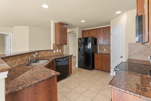 kitchen featuring kitchen peninsula, decorative backsplash, sink, black appliances, and light tile patterned floors