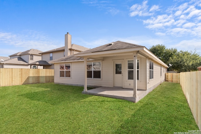 rear view of property with a lawn and a patio area