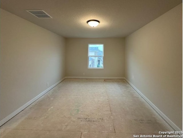 spare room with a textured ceiling