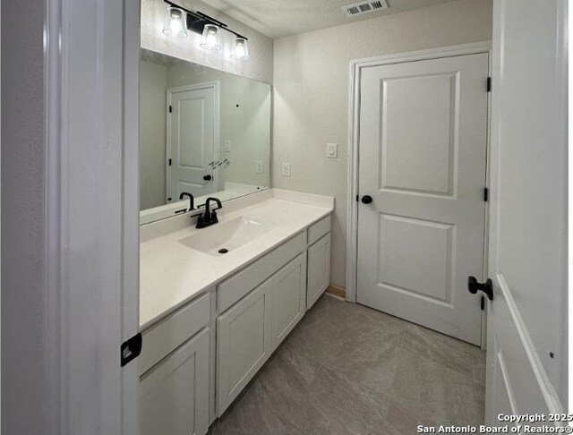 bathroom featuring vanity and a textured ceiling