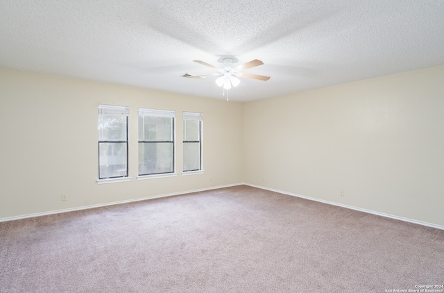 spare room featuring ceiling fan, carpet, and a textured ceiling