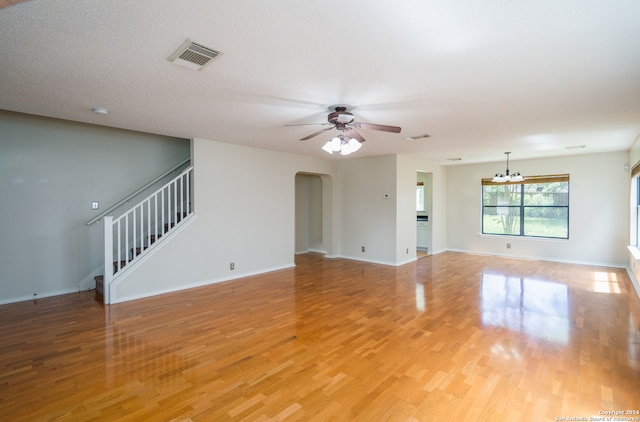 unfurnished living room featuring light hardwood / wood-style floors and ceiling fan with notable chandelier