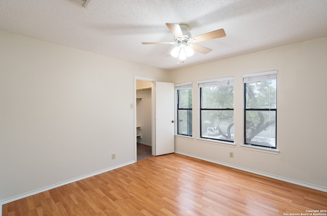 spare room featuring a textured ceiling, light hardwood / wood-style flooring, and ceiling fan