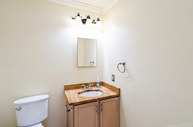 bathroom with vanity, toilet, and crown molding