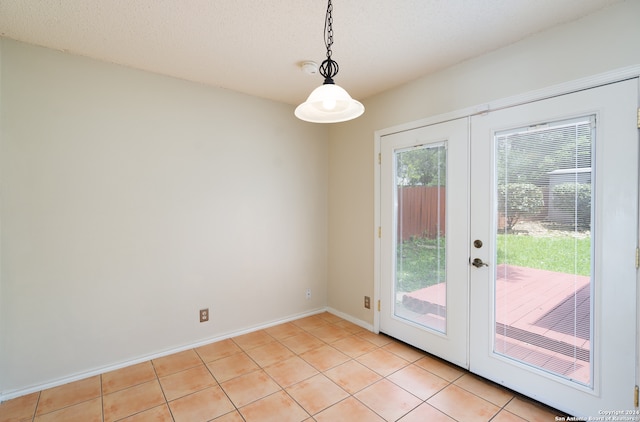 doorway featuring french doors, light tile patterned floors, and a textured ceiling