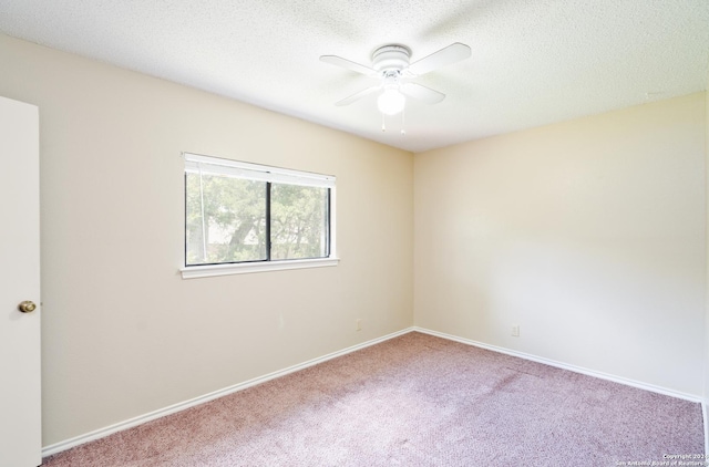 carpeted empty room with ceiling fan and a textured ceiling