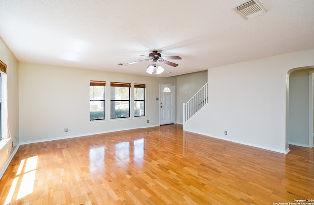 unfurnished room with ceiling fan, light hardwood / wood-style flooring, and a textured ceiling