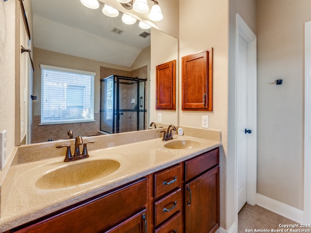 bathroom featuring vanity, vaulted ceiling, tile patterned floors, and a shower with shower door