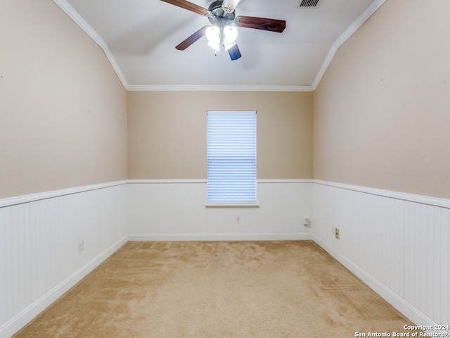 carpeted spare room featuring crown molding, ceiling fan, and lofted ceiling