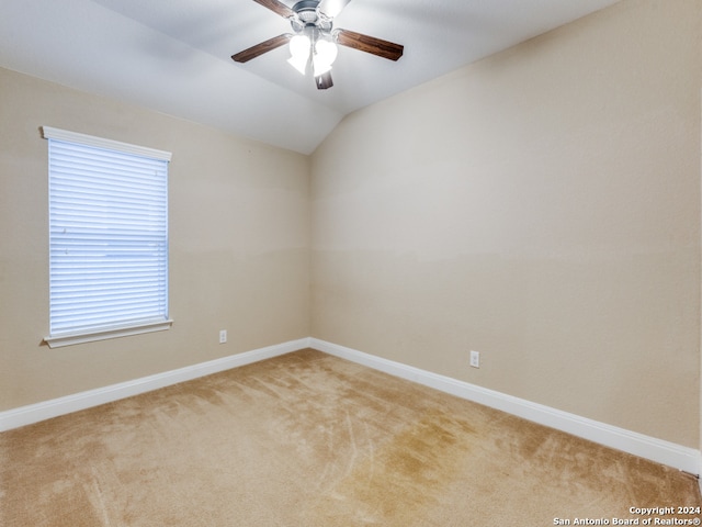 carpeted empty room with vaulted ceiling and ceiling fan