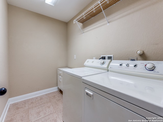 washroom with washing machine and dryer and light tile patterned flooring