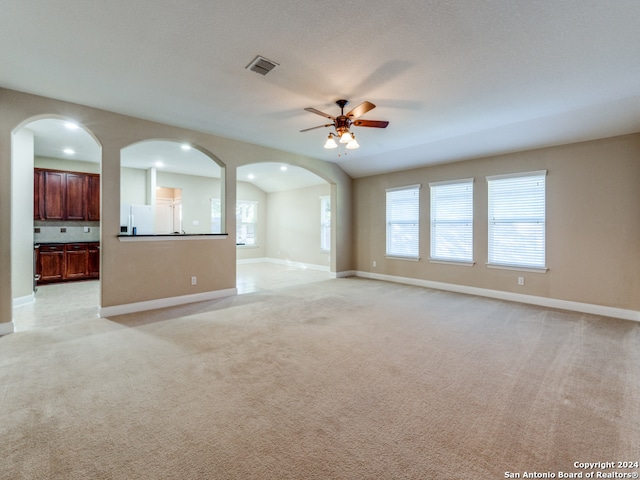 unfurnished living room with ceiling fan and light colored carpet