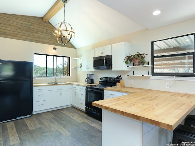 kitchen with wood counters, white cabinetry, hanging light fixtures, and black appliances