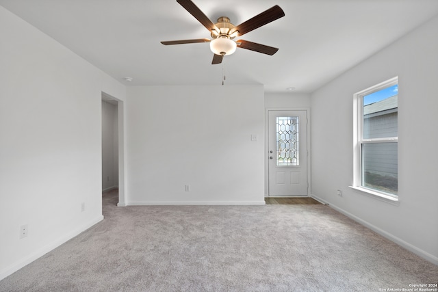 carpeted spare room featuring ceiling fan