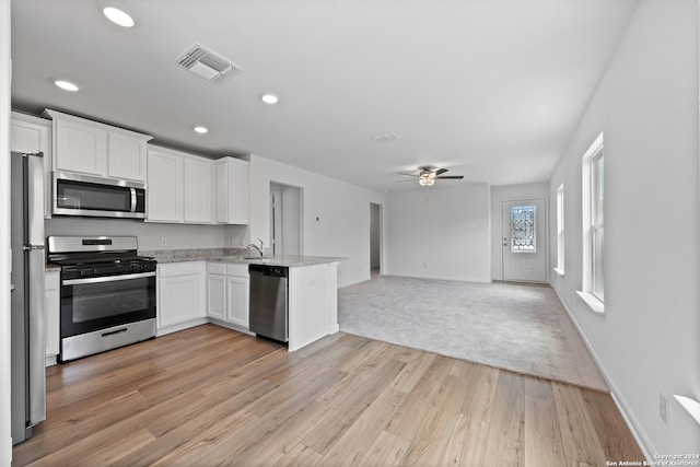 kitchen with ceiling fan, white cabinets, light hardwood / wood-style floors, and appliances with stainless steel finishes