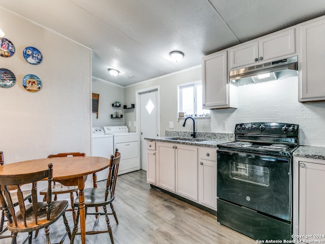 kitchen with white cabinetry, electric range, and independent washer and dryer