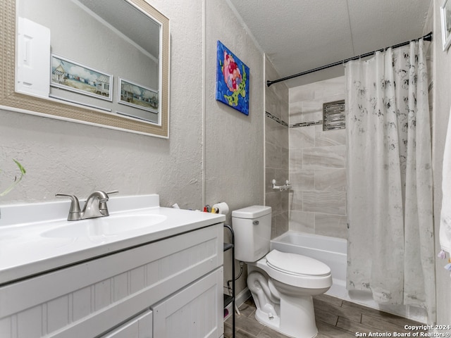 full bathroom featuring vanity, shower / tub combo, a textured ceiling, and toilet