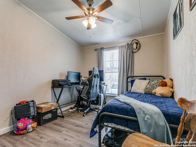 bedroom featuring ceiling fan, light hardwood / wood-style flooring, and ornamental molding