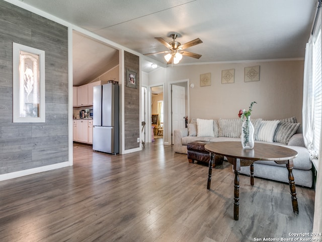 living room with breakfast area, vaulted ceiling, ceiling fan, dark wood-type flooring, and crown molding