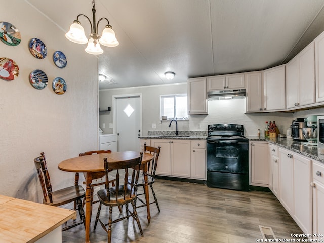 kitchen with white cabinets, black range with electric stovetop, hanging light fixtures, and hardwood / wood-style floors