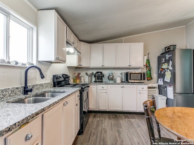 kitchen featuring white cabinetry, stainless steel appliances, lofted ceiling, and light wood-type flooring