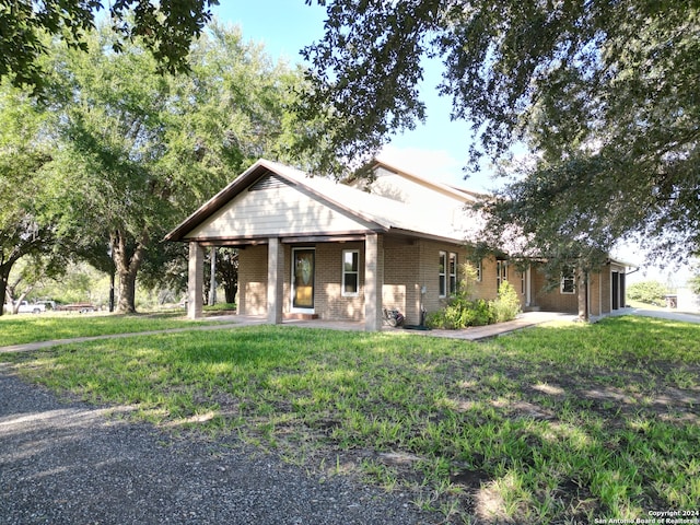 view of front of house with a front lawn, covered porch, and a garage