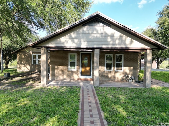 bungalow with a front yard and covered porch