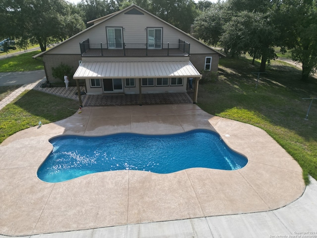 outdoor pool featuring a lawn and a patio