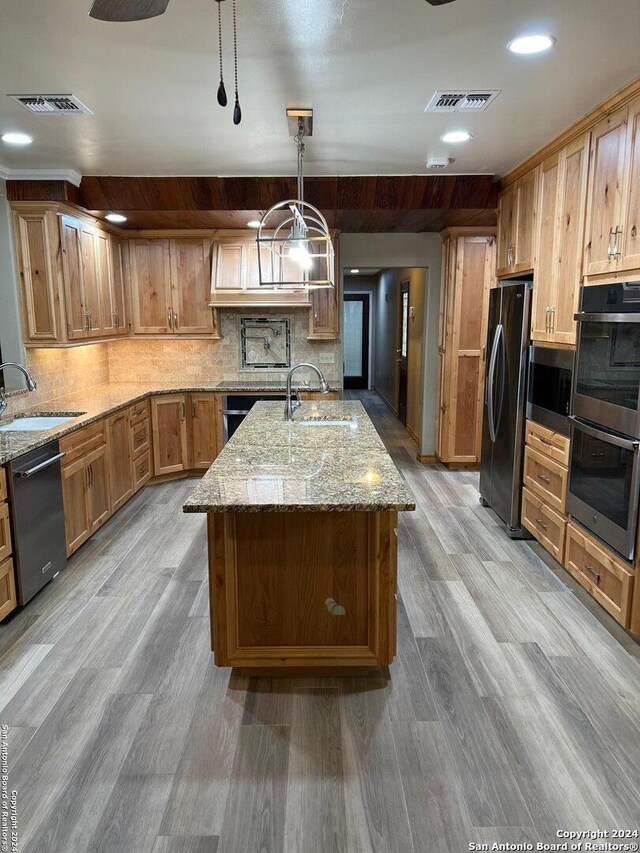 kitchen featuring a center island with sink, visible vents, stainless steel appliances, and a sink