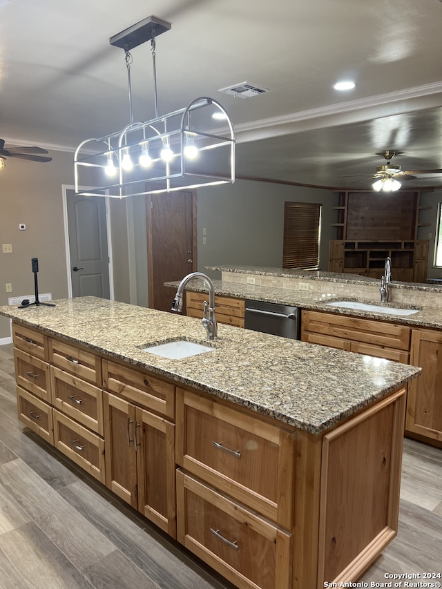 kitchen featuring light stone counters, a sink, stainless steel dishwasher, and a ceiling fan