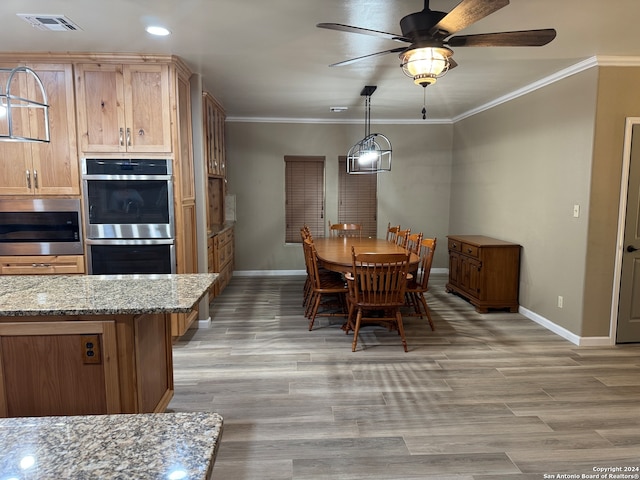 dining room with baseboards, ornamental molding, and wood finished floors