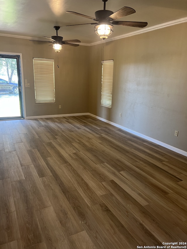 unfurnished room with baseboards, dark wood-type flooring, a ceiling fan, and crown molding