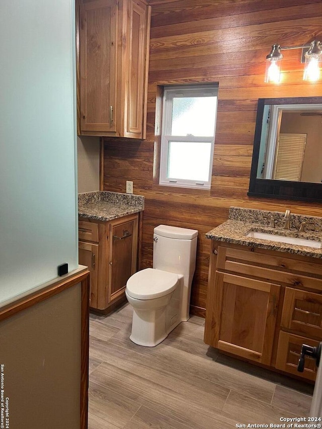 bathroom with toilet, wood finished floors, and vanity