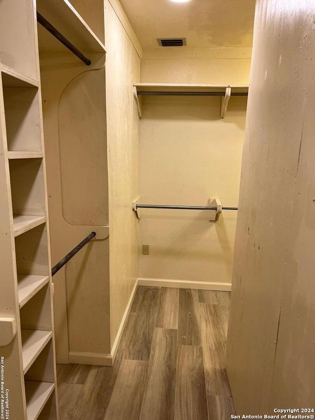 spacious closet featuring visible vents and wood finished floors