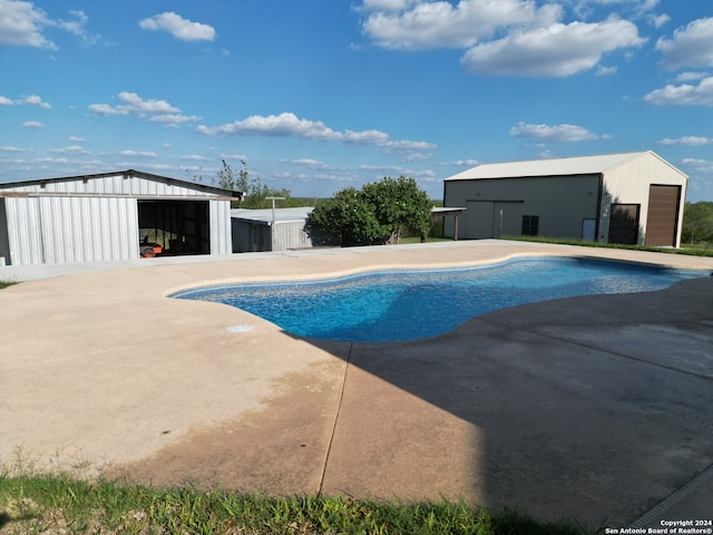 pool featuring fence, an outbuilding, a patio, and an outdoor structure