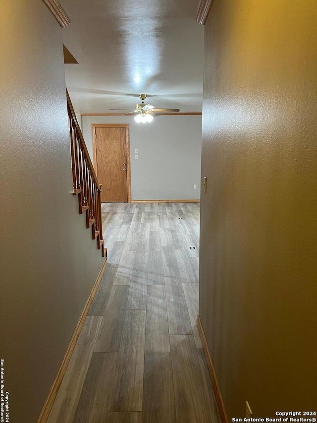 hallway featuring stairs, wood finished floors, and baseboards