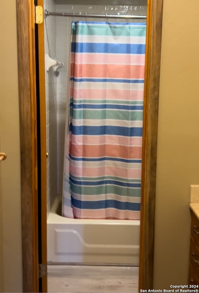 bathroom featuring vanity and shower / bathtub combination with curtain