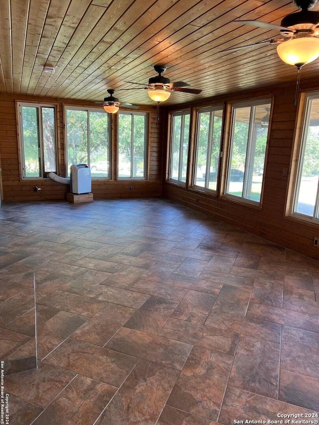 interior space with a healthy amount of sunlight, wooden ceiling, and ceiling fan