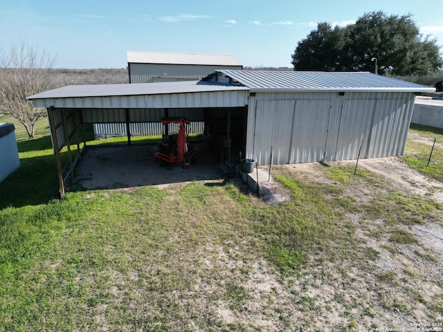 view of pole building featuring a carport, a yard, and driveway