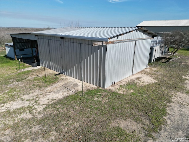 view of property exterior with a pole building, metal roof, board and batten siding, and an outdoor structure