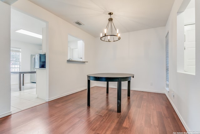 dining space with a notable chandelier and light hardwood / wood-style floors