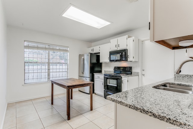 kitchen featuring light stone counters, sink, white cabinets, and black appliances