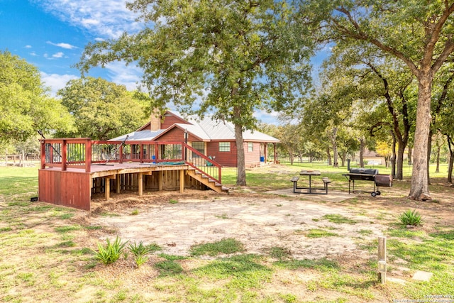 view of playground featuring a yard and a wooden deck