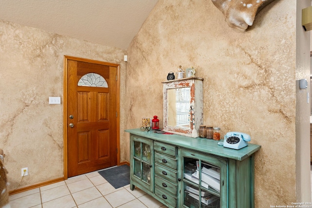 entryway with a textured ceiling and light tile patterned flooring