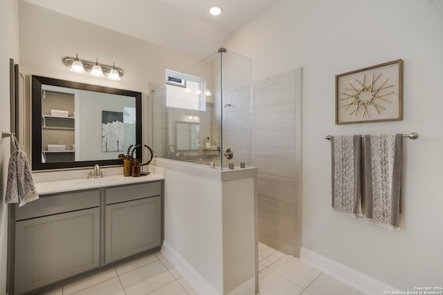 bathroom with tiled shower, vanity, and tile patterned floors