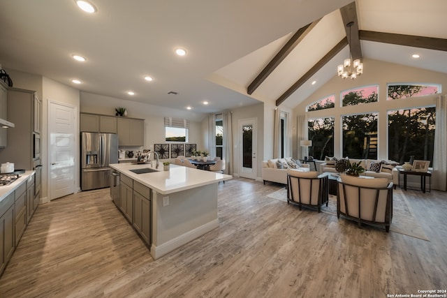 kitchen with a kitchen island with sink, sink, gray cabinets, light wood-type flooring, and appliances with stainless steel finishes